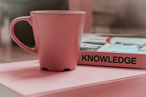 a pink coffee cup sitting on top of a pink table.