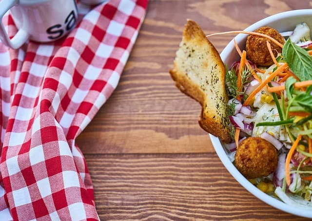 A bowl of food on a table with a checkered tablecloth.